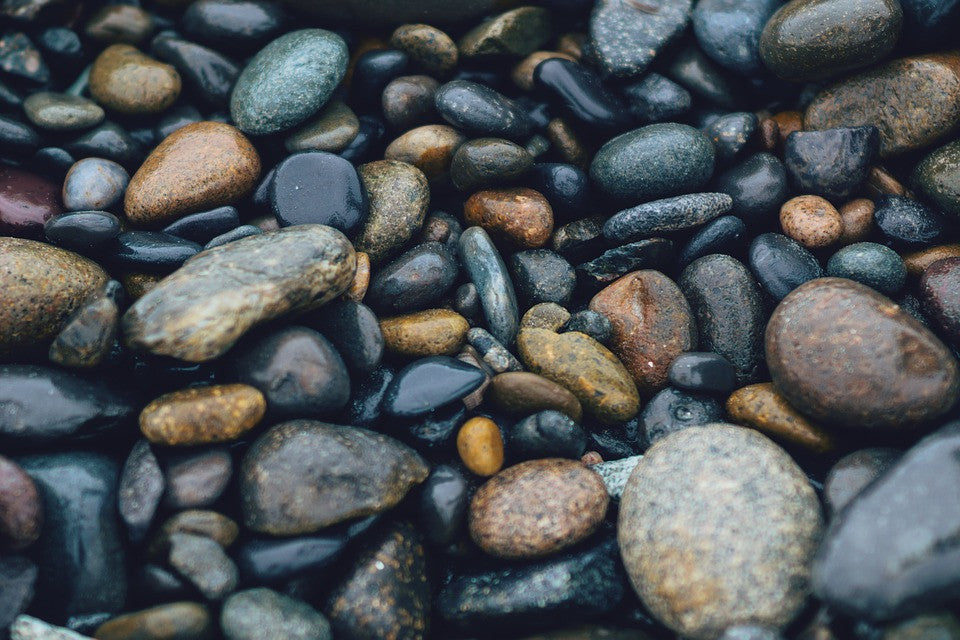 Close up of river pebbles in blue and brown shades